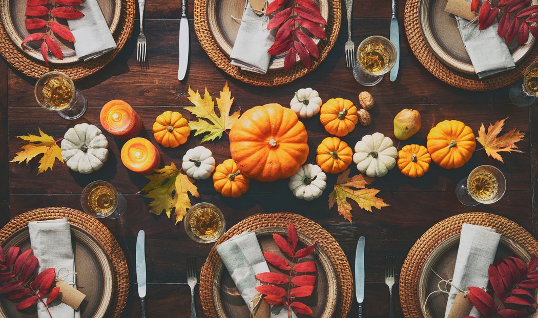 Festlich gedeckter Tisch mit Kürbissen und Herbstdekoration.